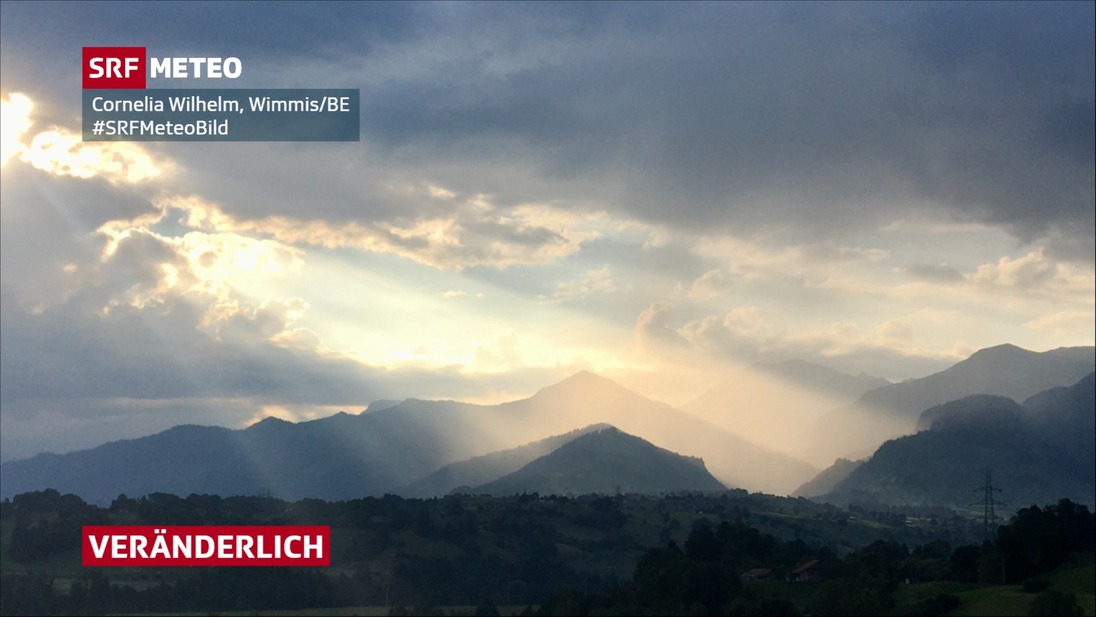 Sonnenstrahlen scheinen durch viele Wolken hindurch.