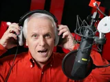 WAM porte des écouteurs et se trouve devant le microphone de la radio.