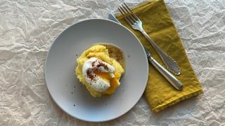Ein Teller mit Kartoffelstock mit pochiertem Ei und brauner Butter.