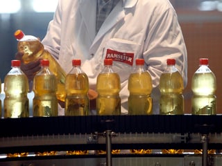 Eine Person überprüft eine Flasche Ramseier Apfelsaft.