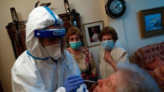 Eine Pflegende testet eine Seniorin auf das Coronavirus.