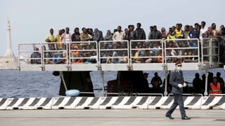 Flüchtlinge warten auf einem Schiff vor Sizilien.
