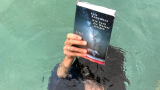Annette König ist unter Wasser und hält das Buch von Anja Kampmann «Wie hoch die Wasser steigen» über das Wasser