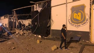 Ein Mann telefoniert vor einem zerstörten Gebäude des angegriffenen Flüchtlingslagers Ein Mann telefoniert vor einem zerstörten Gebäude des angegriffenen Flüchtlingslagers