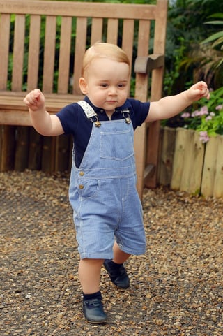 Prinz George in blauen Latzhosen gehend. Prinz George in blauen Latzhosen gehend.