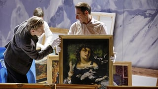 Drei Personen sehen sich Gemälde an.