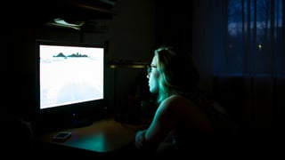 eine junge Frau schaut am Computer eine Sendung eine junge Frau schaut am Computer eine Sendung