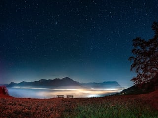 Blick auf das Nebelmeer unter dem Sternenhimmel