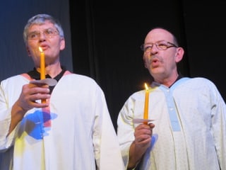 Zwei Sänger mit Kerze im Nachthemd.