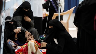 Frauen in Burka pflegen ein schreiendes Kind