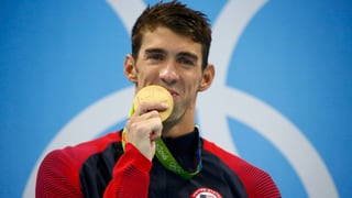 Michael Phelps küsst seine Goldmedaille.