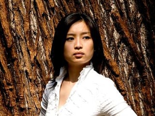 Mei Yi Foo steht vor einem Baum.