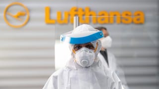 Frau in Schutzkleidung am Flughafen Frau in Schutzkleidung am Flughafen