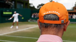 Mann mit Hut schaut Tennis in Wimbledon.