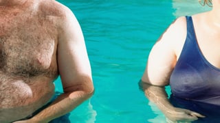 Füllige Körper eines Mannes und einer Frau nebeneinander in einem Schwimmbecken.