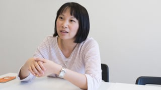 Eine Frau sitzt an einem Tisch Eine Frau sitzt an einem Tisch
