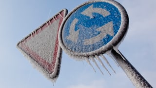 Verkehrsschilder mit Eis bedeckt.