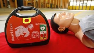 Defibrillator neben Übungspuppe