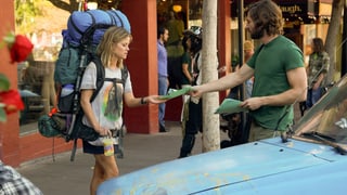 Reese Witherspoon in der Stadt mit riesigem Rucksack erhält Flyer von jungem Mann.