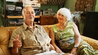 Ein älterer Mann und eine Frau sitzen auf einem Sofa