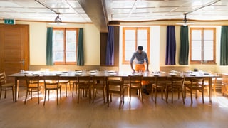 Eine Person deckt einen Tisch in einem Asylzentrum