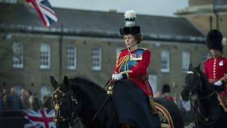 Eine Frau sitzt in Uniform auf einem Pferd. Eine Frau sitzt in Uniform auf einem Pferd.