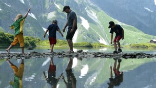 Vater mit drei Kindern an einem See