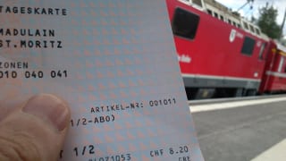Bahnbillett vor Zug der Rhätischen Bahn.