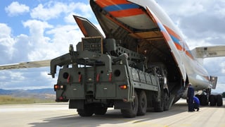 Ein Militärfahrzeug verlässt den Bauch eines Transportflugzeugs. Ein Militärfahrzeug verlässt den Bauch eines Transportflugzeugs.