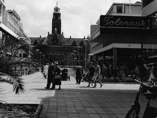 Eine Einkaufstrasse in Rotterdam aus den 50er-Jahren. Ein paar Menschen sind im Bild.