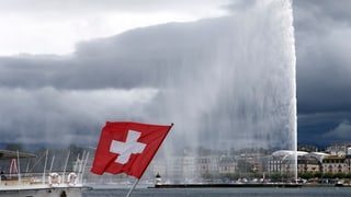 Der Jet d'eau in Genf am See. Vorne links eine Schweizer Fahne.