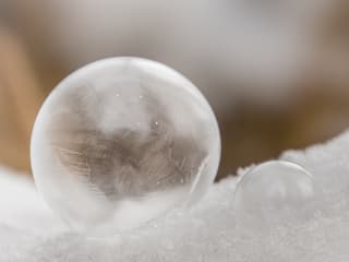 Eine gefrorene Seifenblase im Schnee.