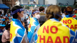 Südkoreaner demonstrieren, über ihre Schultern haben sie Transparente mit der Aufschrift «No THAAD» gehängt.