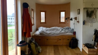 Blick in die Schlafecke eines kleines Holzhauses 