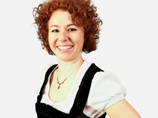 Lockenkopf Nadja Räss posiert fröhlich-lachend für ein Porträt-Foto.