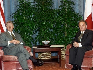 Zwei Personen in Sofas sitzend.