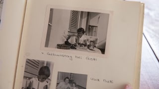 Blick in ein Fotoalbum: Unter anderem mit einer Schwarz-Weiss-Aufnahme eines Mädchens an einem Tisch. Darunter steht: "4. Geburtstag bei Gotti". 