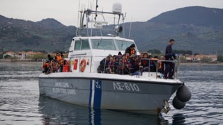 Kleinboot der griechischen Küstenwache mit Migranten in Schwimmwesten an Bord.