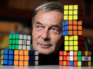 Ernö Rubik, der Erfinder des Zauberwürfels, zwischen farbigen Würfeln.