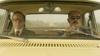 Zwei Männer sitzen im Auto.