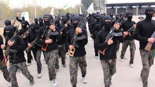 Ahrar al-Scham-Kämpfer mit verhülltem Gesicht und Gewehren.