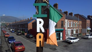 Blick in eine nordirische Strasse. Ein IRA-Logo hängt an einem Pfosten.