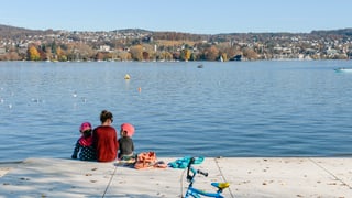 Familie an See mit Fahrrad.