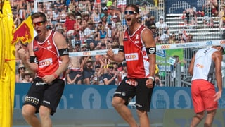 Die beiden Spieler jubelnd auf dem Beachvolley-Feld Die beiden Spieler jubelnd auf dem Beachvolley-Feld