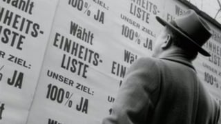 Mann steht vor Plakatwand mit nur einer Wahlliste. Mann steht vor Plakatwand mit nur einer Wahlliste.