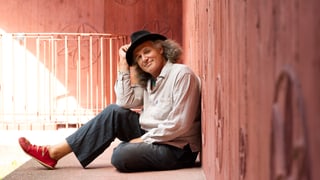 Linard Bardill posiert sitzend.