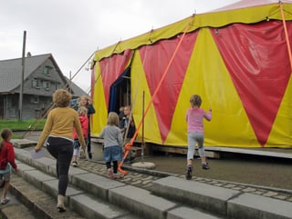 Kinder laufen auf Zirkuszelt zu