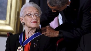 Obama legt der 79-jährigen Katherine Johnson die Medallie um den Hals.