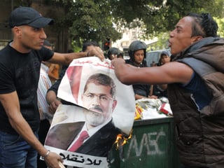 Mursi-Gegner verbrennen ein Plakat des gestürzten Präsidenten.