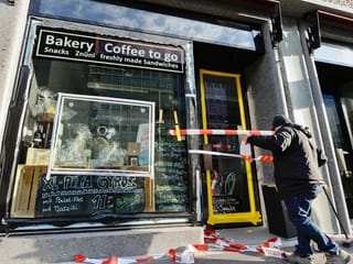 Ein MItarbeiter einer Glasfirma misst eine zu ersetzende Glasscheibe an einem Café im Zürcher Kreis 4 aus.